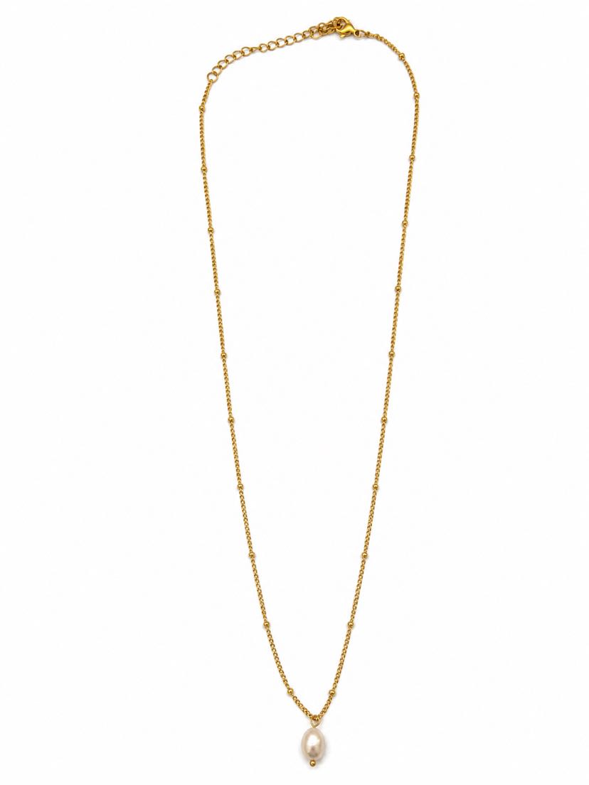Collier Perla à plat sur fond crème, chaîne satellite très fine d'or à billes régulièrement espacées et une seule perle baroque blanche pendante en goutte au centre bas
